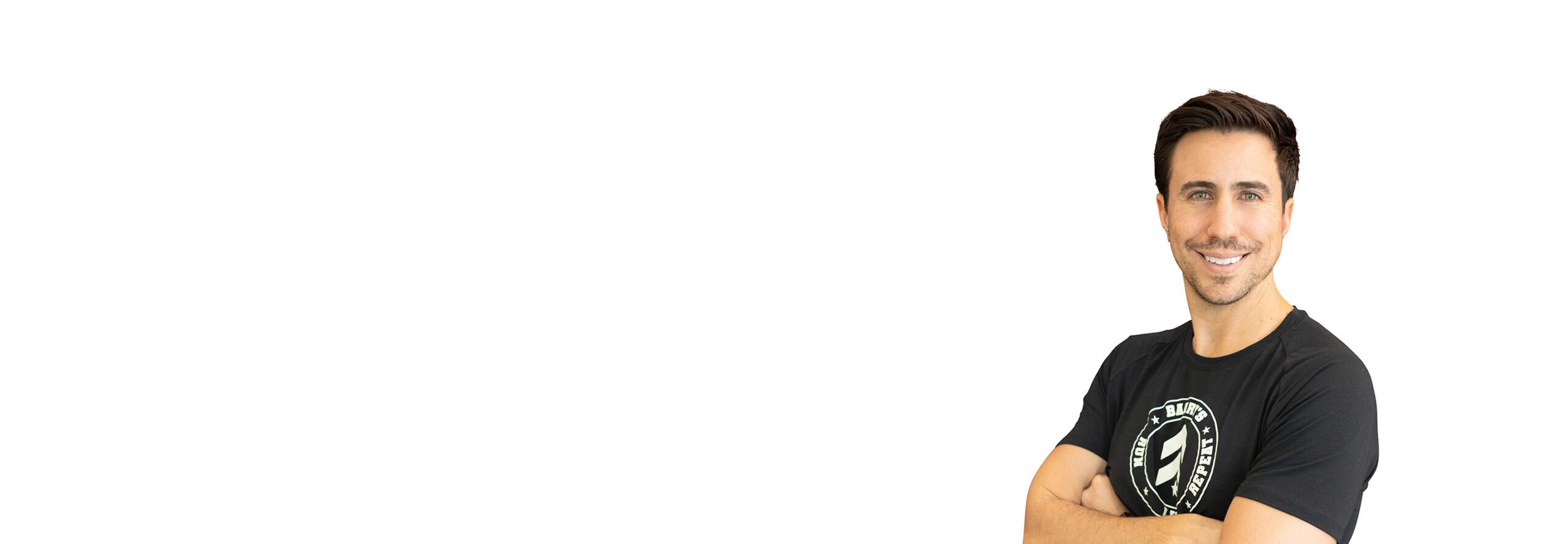 Barry’s instructor wearing a black top standing confidently smiling against a white background