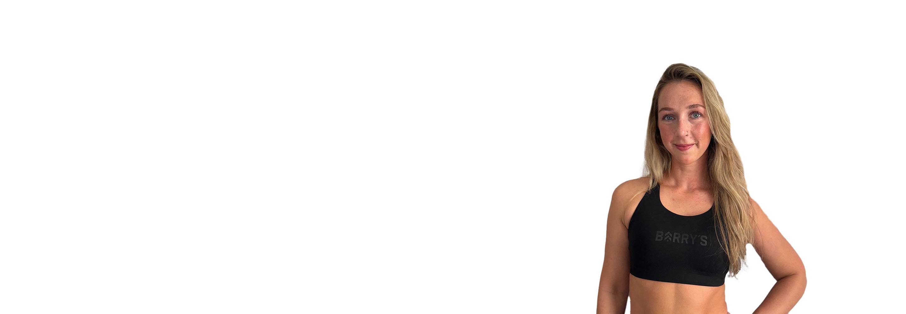 Barrys instruktör iklädd en svart topp står självsäkert och ler mot en vit bakgrund