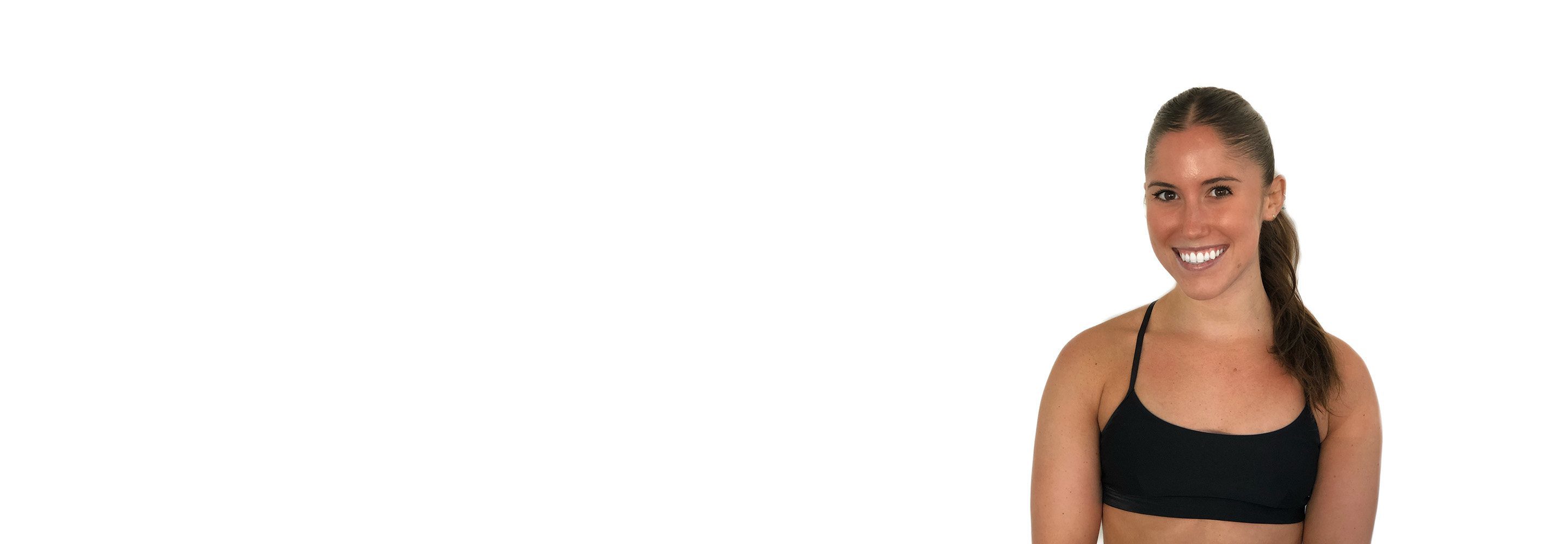 Barry’s instructor wearing a black top standing confidently smiling against a white background