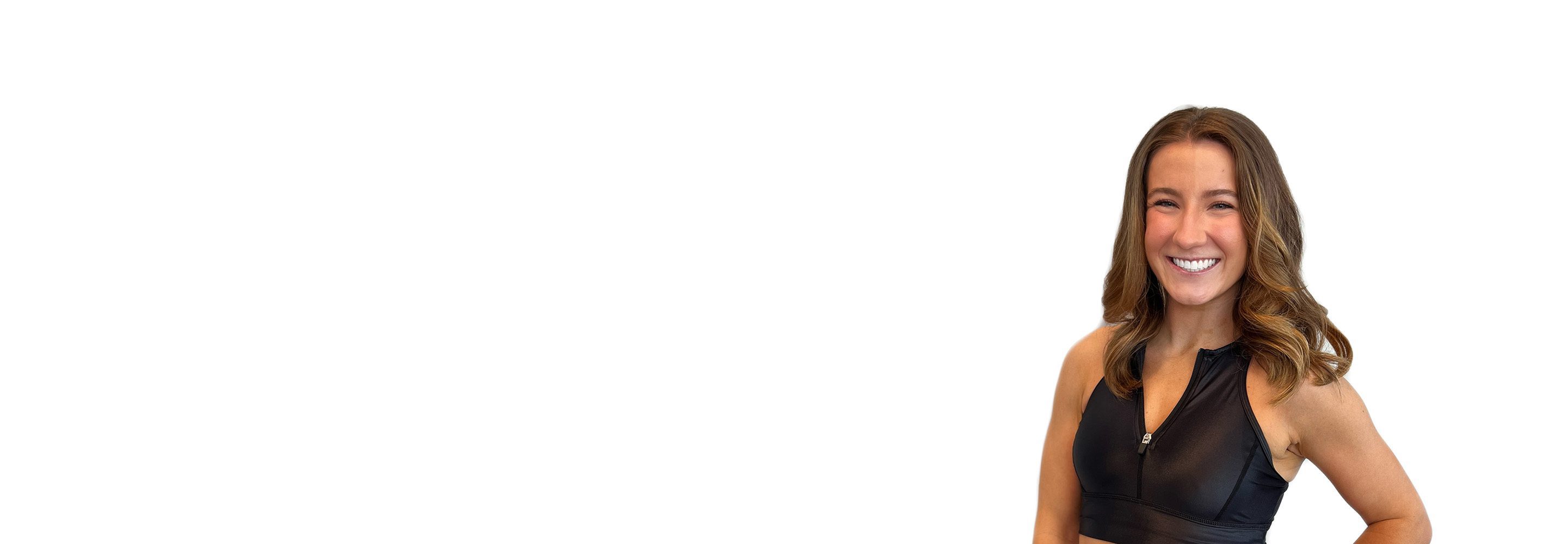 Barrys instruktör iklädd en svart topp står självsäkert och ler mot en vit bakgrund