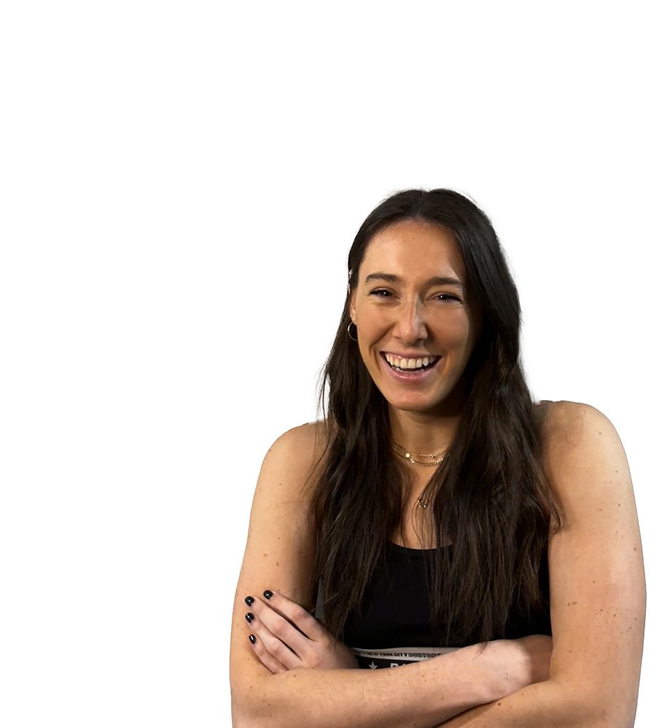 Barry's instructor standing confidently wearing a black tank top against a white background, ready for the next workout challenge.