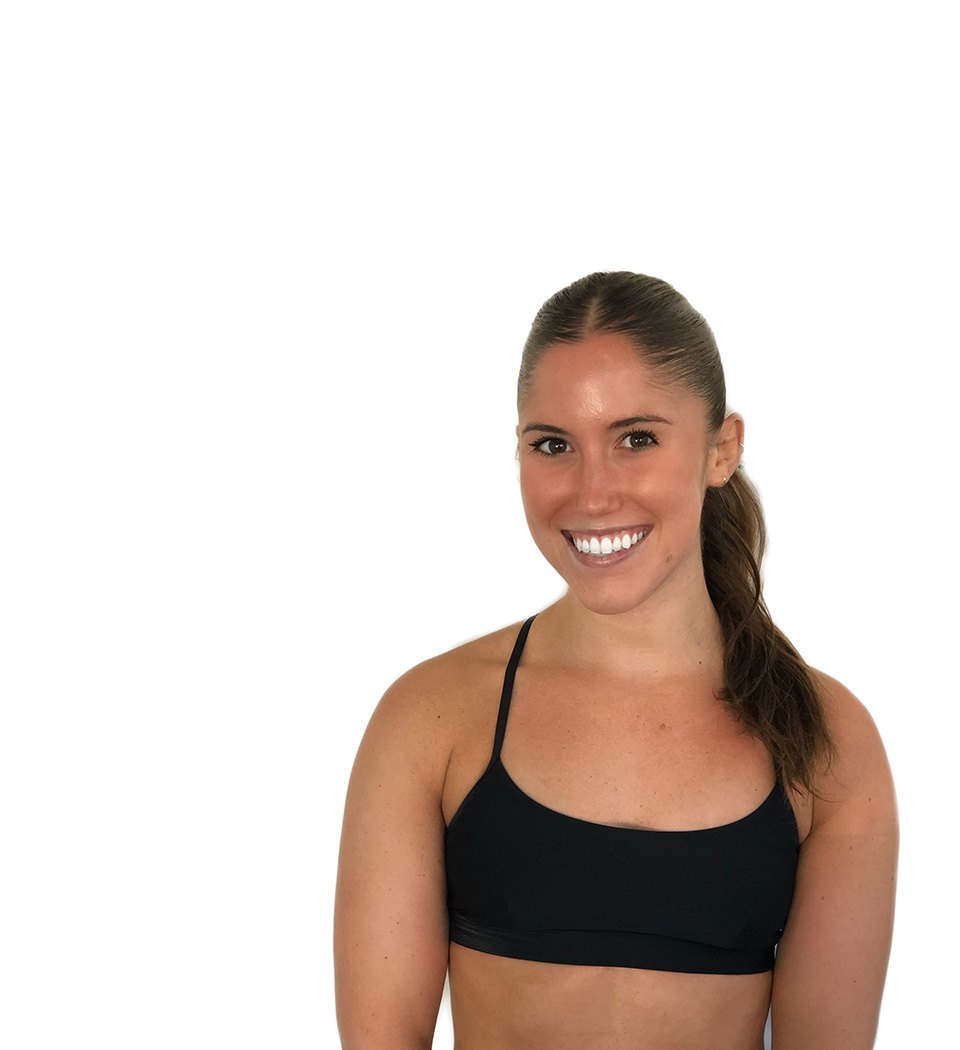 Barry’s instructor wearing a black top standing confidently smiling against a white background