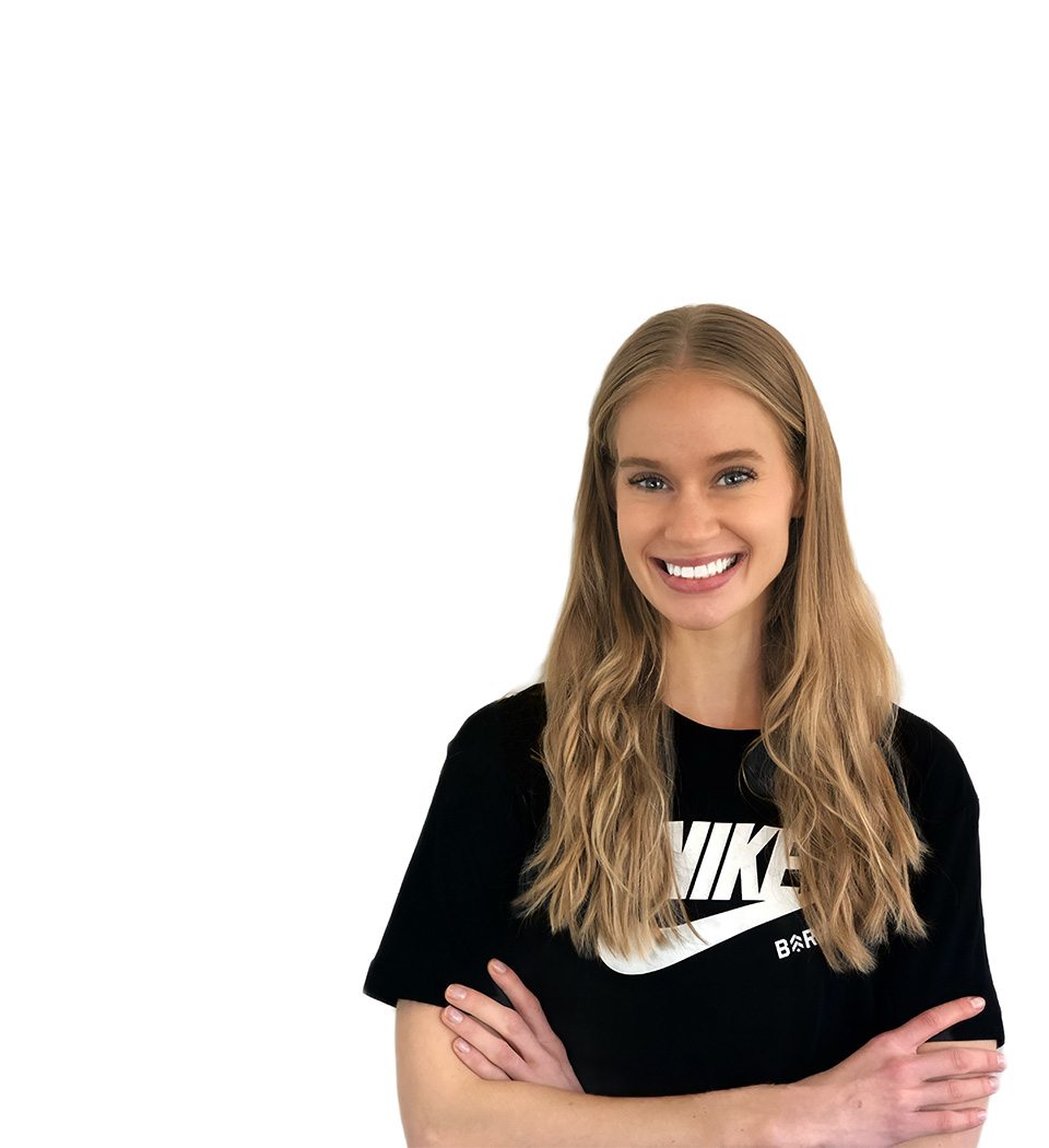 Barry’s instructor wearing a black top standing confidently smiling against a white background