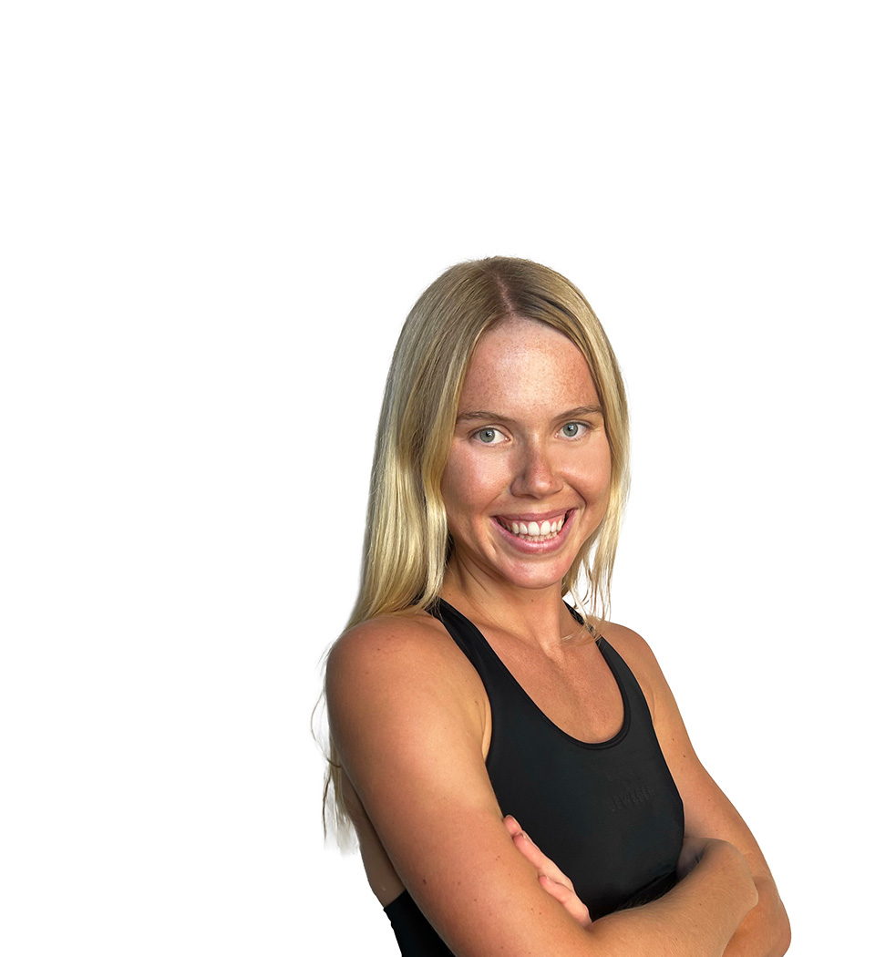 Barry’s instructor wearing a black top standing confidently smiling against a white background