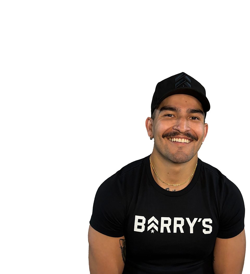 Barry's instructor standing confidently, wearing a black tank top against a white background, ready for the next workout challenge.