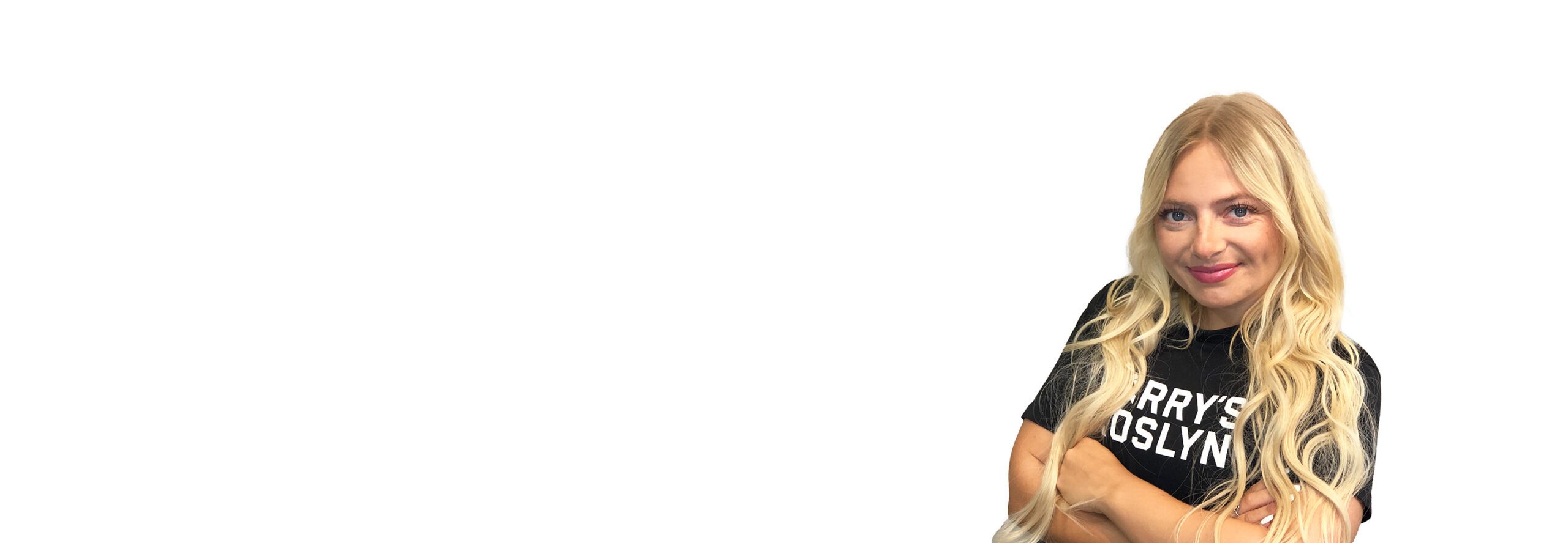 Barry’s instructor wearing a black top standing confidently smiling against a white background