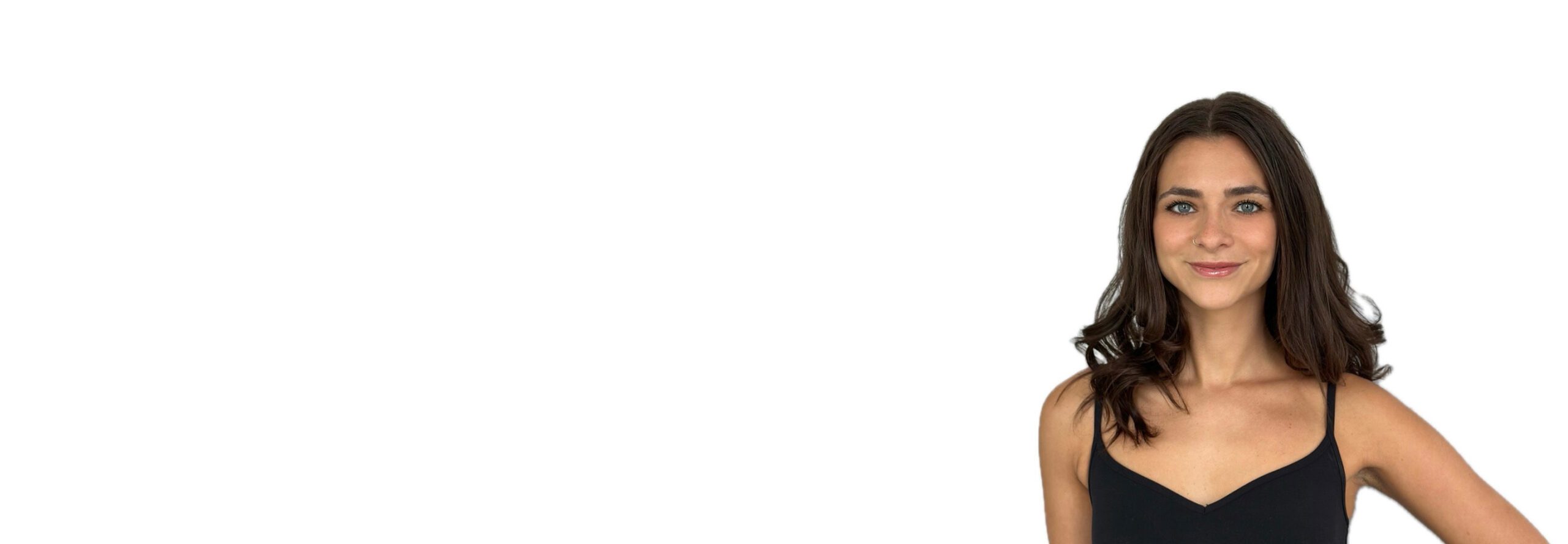 Barry’s instructor wearing a black top standing confidently smiling against a white background