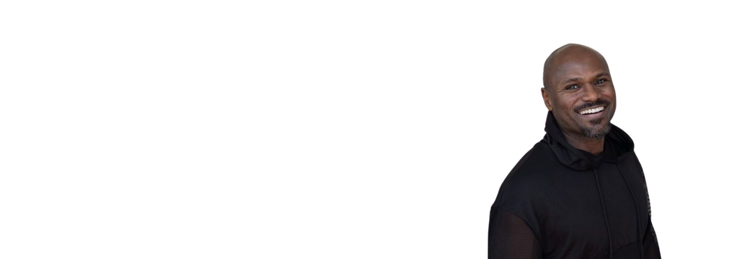 Barry’s instructor wearing a black top standing confidently smiling against a white background