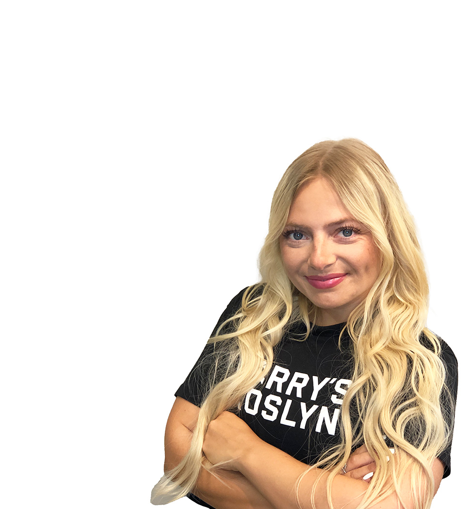 Barry’s instructor wearing a black top standing confidently smiling against a white background