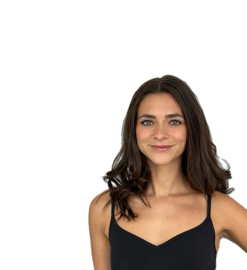 Barry’s instructor wearing a black top standing confidently smiling against a white background