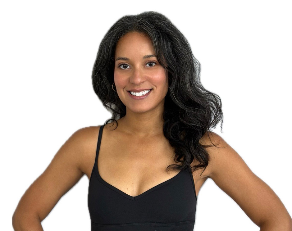 Barry’s instructor wearing a black top standing confidently smiling against a white background