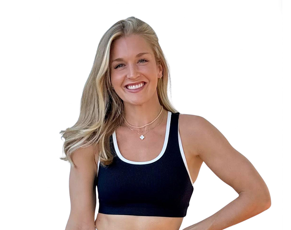 Barry’s instructor wearing a black top standing confidently smiling against a white background