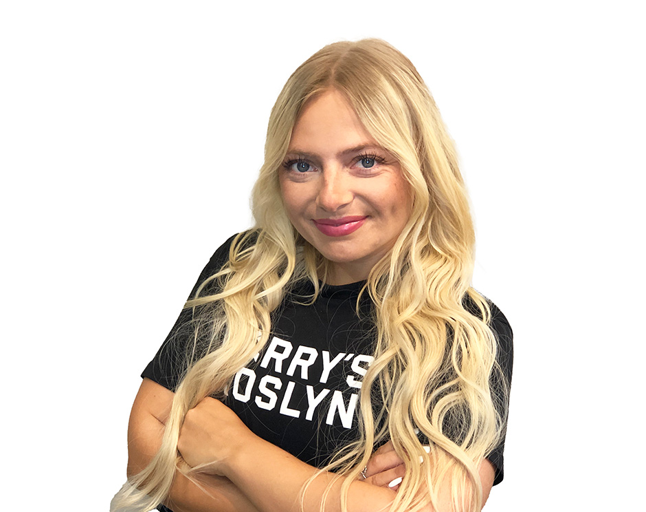 Barry’s instructor wearing a black top standing confidently smiling against a white background