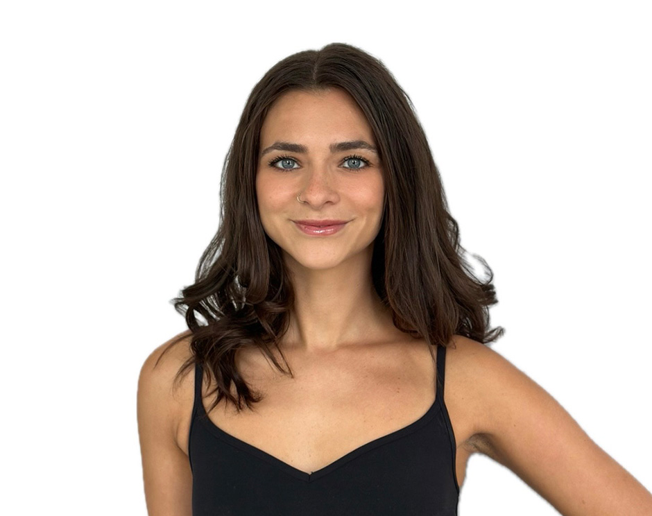 Barry’s instructor wearing a black top standing confidently smiling against a white background