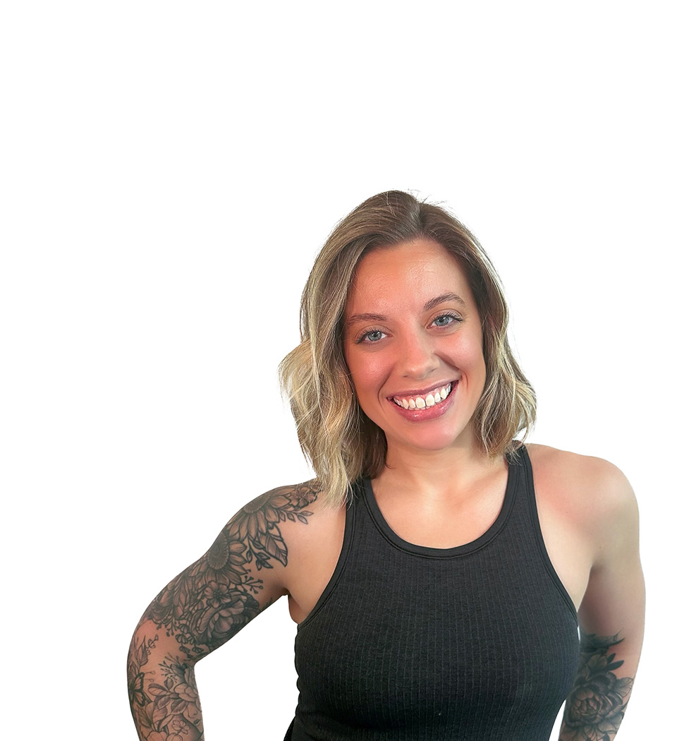 Barry’s instructor wearing a black top standing confidently smiling against a white background