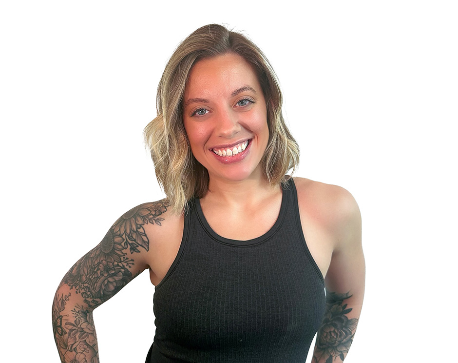 Barry’s instructor wearing a black top standing confidently smiling against a white background