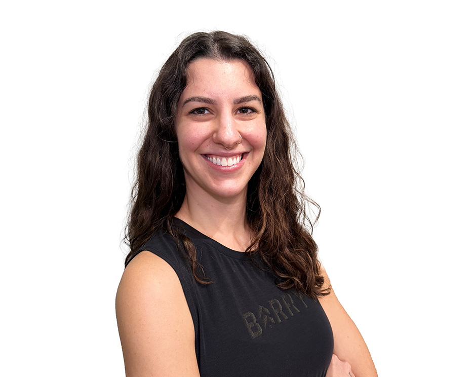 Barry’s instructor wearing a black top standing confidently smiling against a white background
