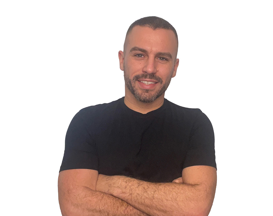 Barry’s instructor wearing a black top standing confidently smiling against a white background