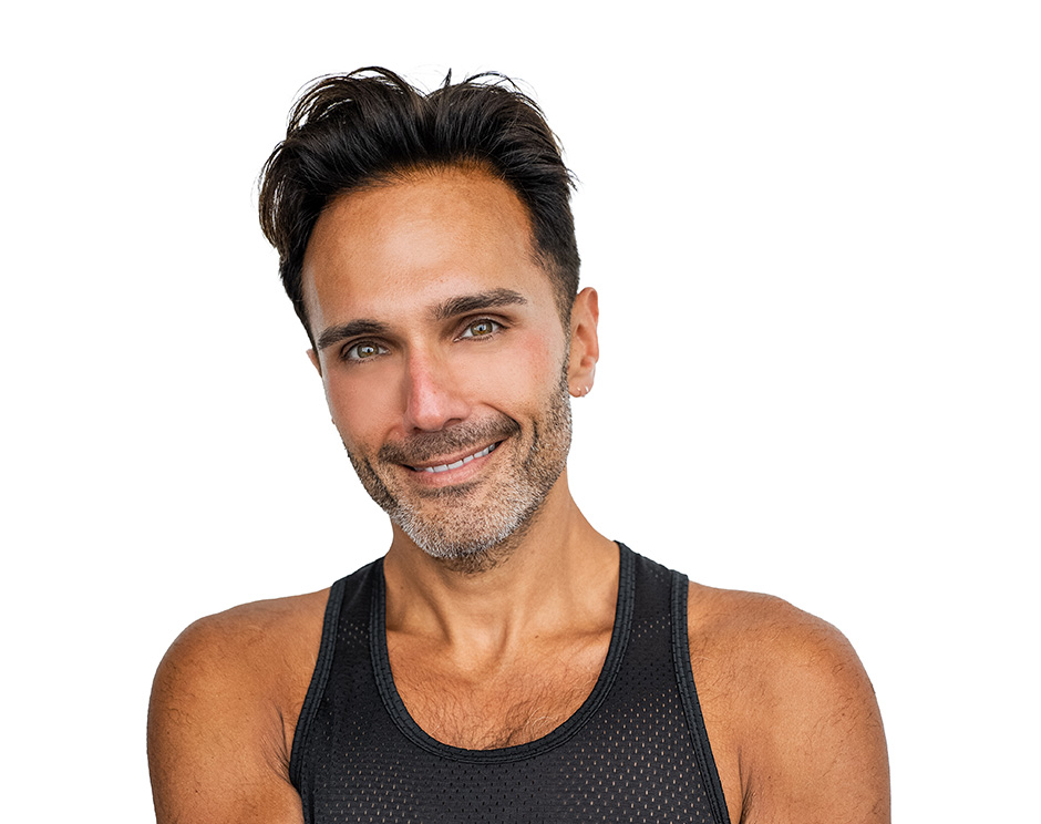 Barry’s instructor wearing a black top standing confidently smiling against a white background