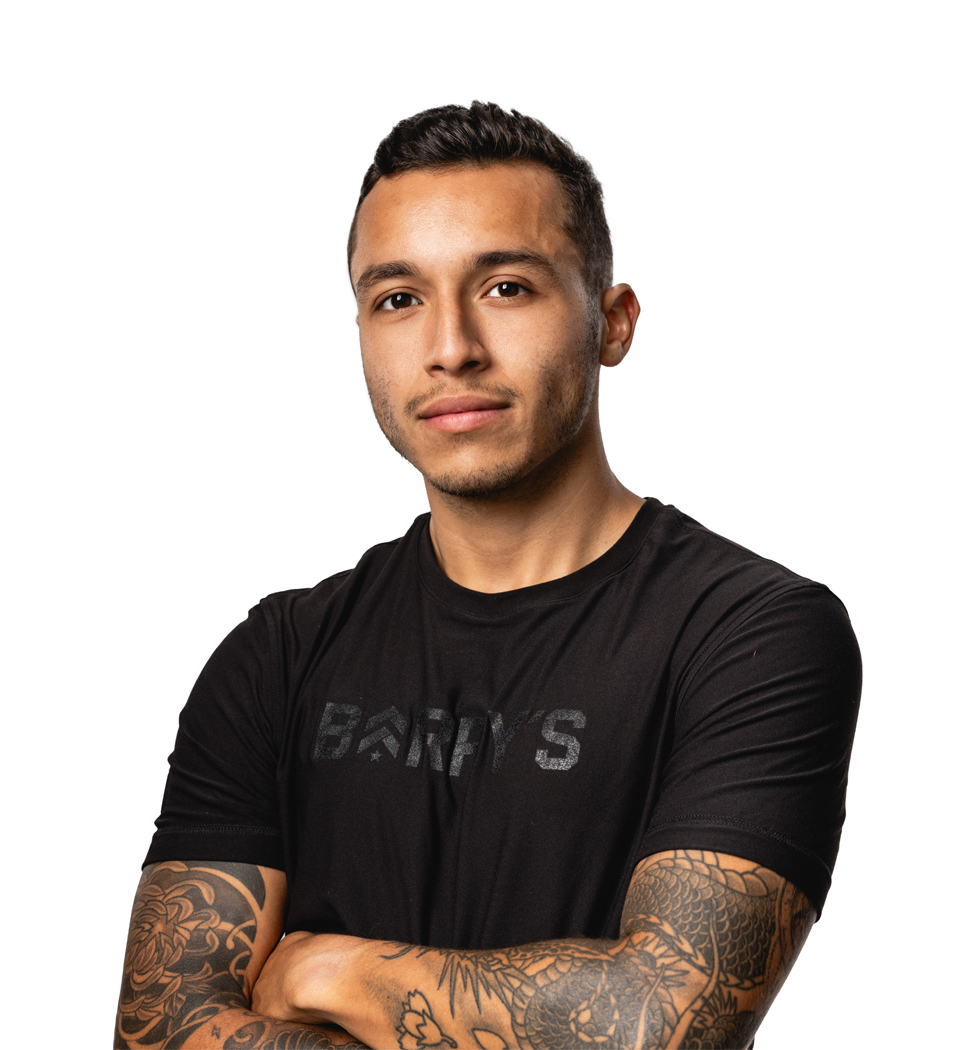 Barrys instruktör står självsäkert klädd i en svart topp mot en vit bakgrund.