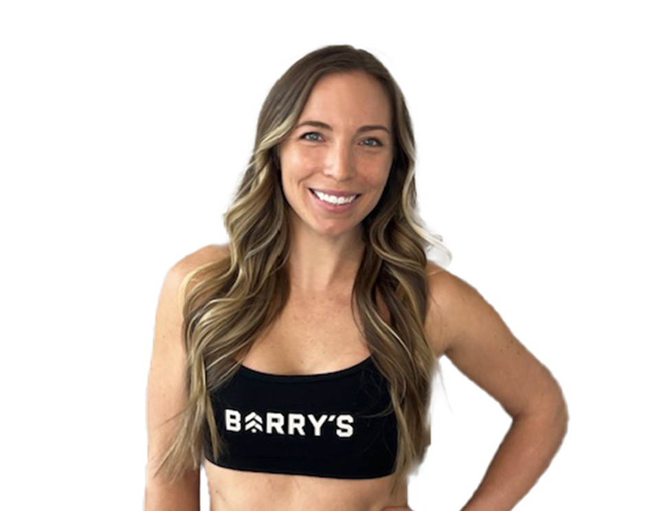 Barry’s instructor wearing a black top standing confidently smiling against a white background