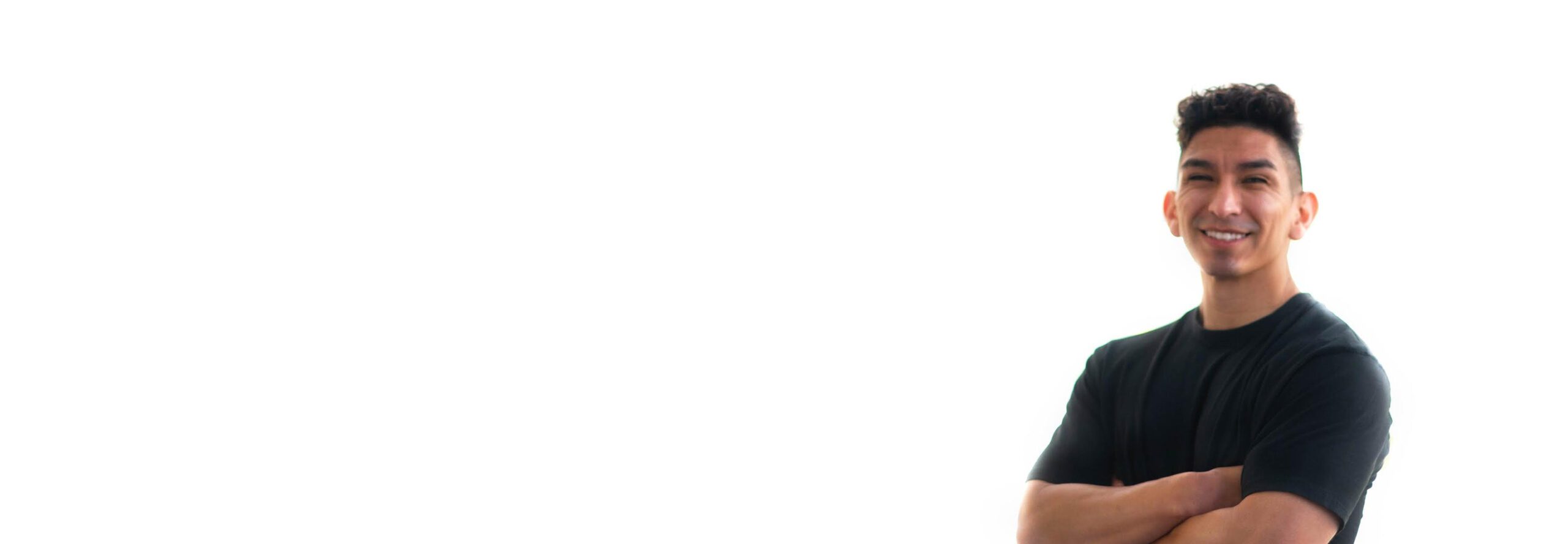 Barrys instruktör står självsäkert, iklädd ett svart linne mot en vit bakgrund, redo för nästa träningsutmaning.