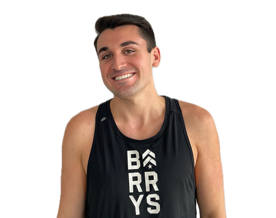 Barry's instructor standing confidently and smiling wearing a black top against a white background.