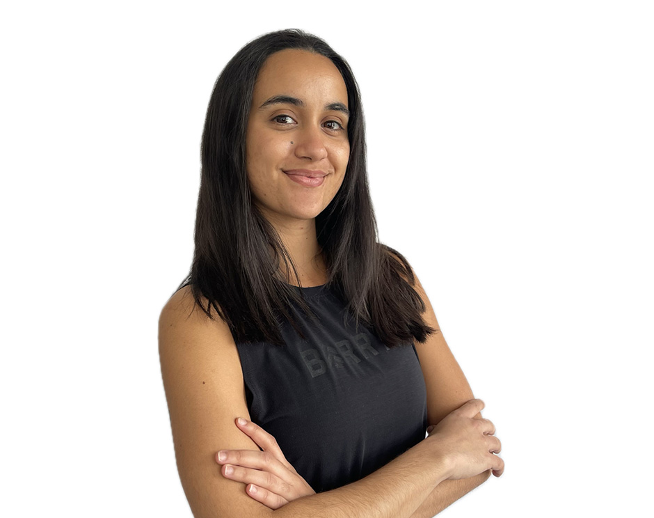 Barry’s instructor wearing a black top standing confidently smiling against a white background