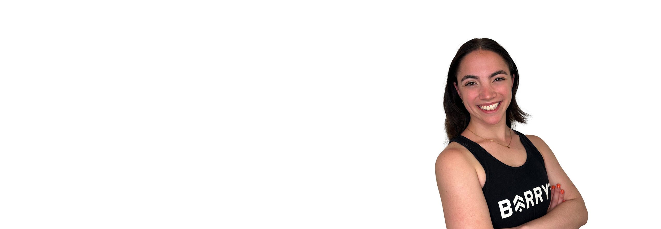 Barry’s instructor wearing a black top standing confidently smiling against a white background