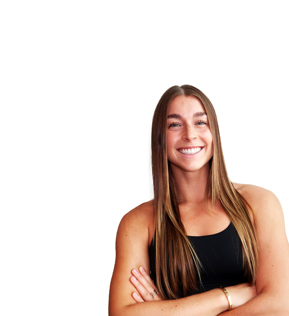 Barry’s instructor wearing a black top standing confidently smiling against a white background