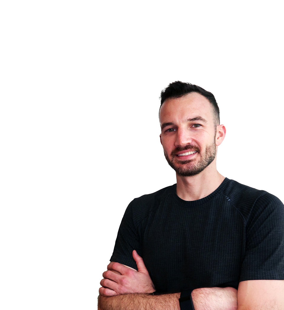 Barry’s instructor wearing a black top standing confidently smiling against a white background