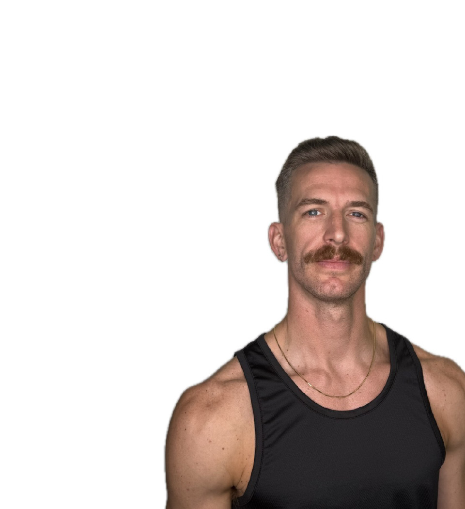 Barry’s instructor wearing a black top standing confidently smiling against a white background