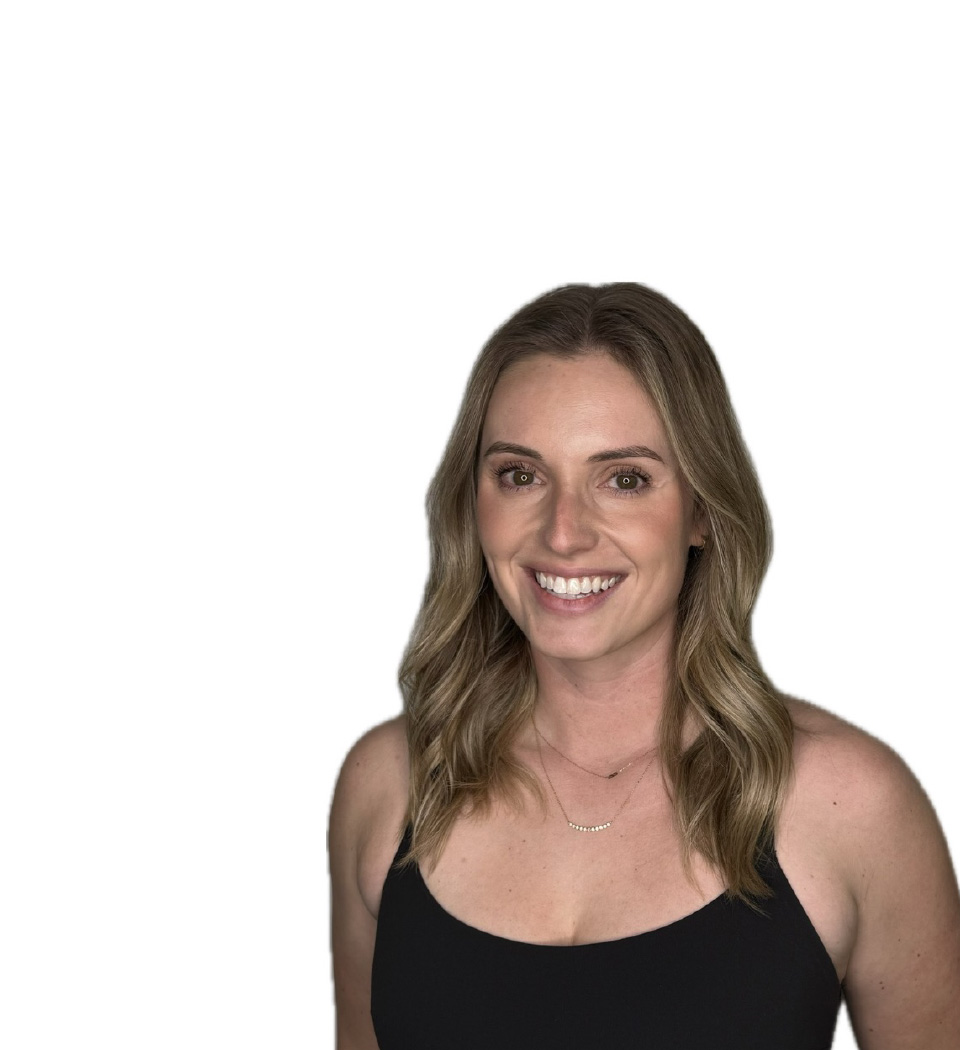 Barry’s instructor wearing a black top standing confidently smiling against a white background