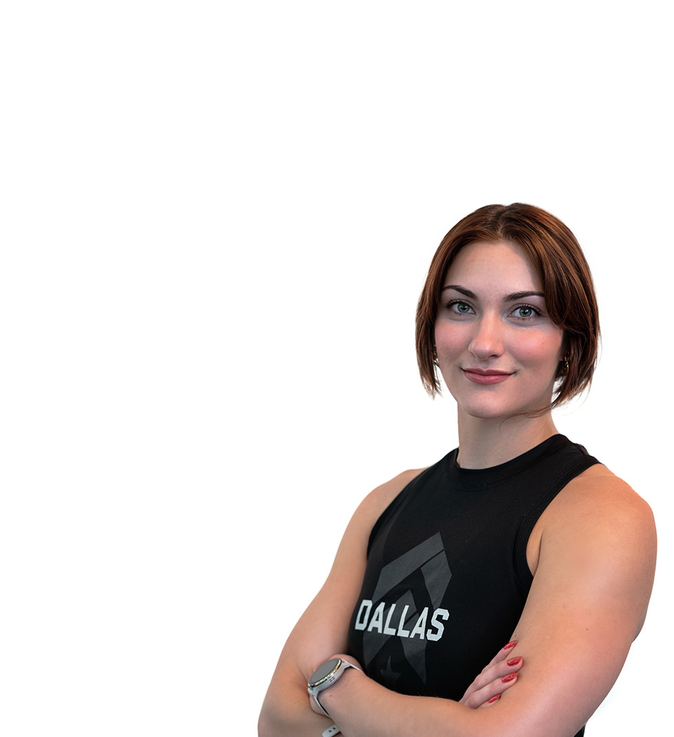 Barry’s instructor wearing a black top standing confidently smiling against a white background