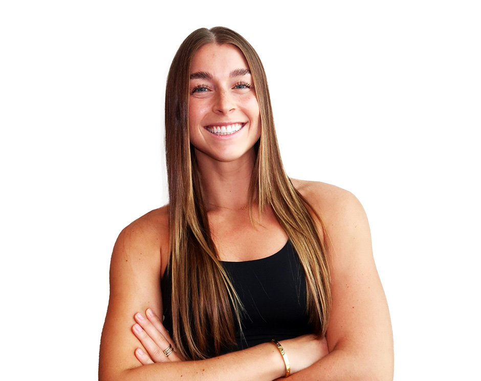 Barry’s instructor wearing a black top standing confidently smiling against a white background