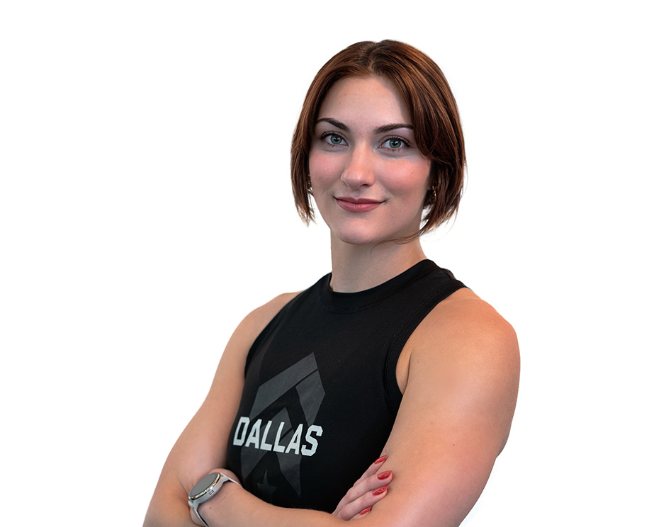 Barry’s instructor wearing a black top standing confidently smiling against a white background