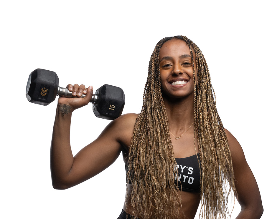 Barry’s instructor wearing a black top standing confidently smiling against a white background